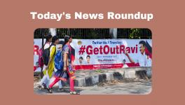 Young women walk past posters that read '#GetOutRavi' pasted on a wall, a day after Tamil Nadu Governor R.N. Ravi walked out of the State Assembly during Assembly Session, in Chennai, Tuesday, Jan. 10, 2023.