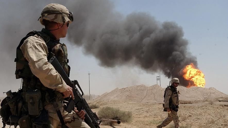 A US Army soldier watching a burning oil well at Rumaila oil field in Iraq in April 2003. Photo: US Navy