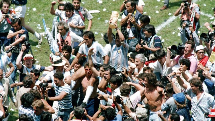 Argentine soccer star Diego Maradona, center, sits on the shoulders of celebrating fans while holding up the FIFA trophy in Mexico City, June 29, 1986. Photo: AP